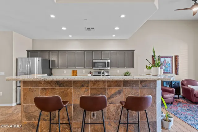 a kitchen with a table chairs refrigerator and cabinets