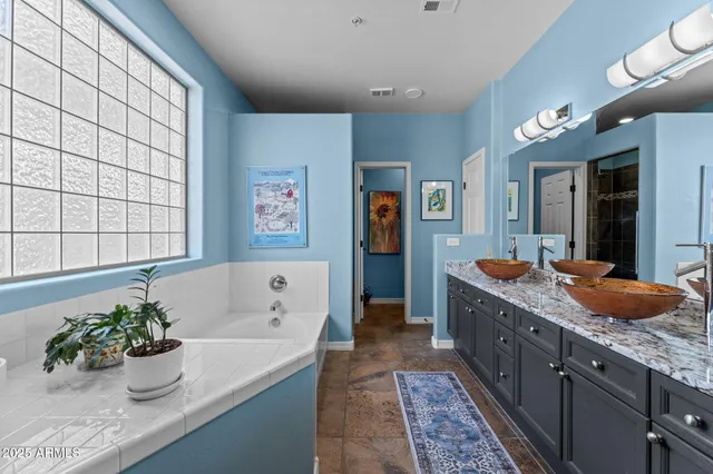 a spacious bathroom with a granite countertop sink and a large mirror