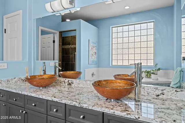 a living room with granite countertop a sink and a mirror