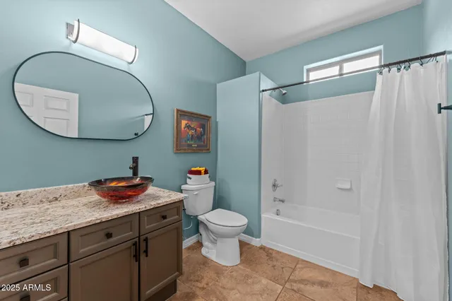 a bathroom with a granite countertop sink a toilet and a mirror