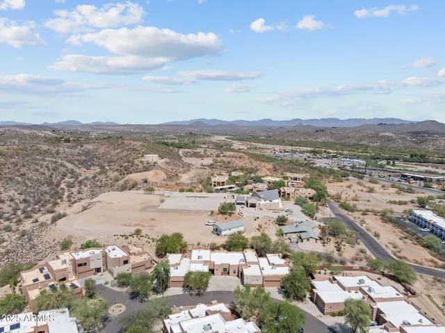 an aerial view of residential houses with outdoor space and trees