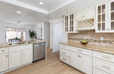 a kitchen with granite countertop white cabinets and white stainless steel appliances