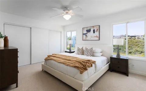 a spacious bedroom with a bed and a chandelier