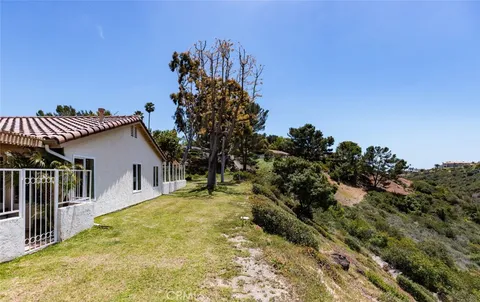 a view of a house with a yard and potted plants