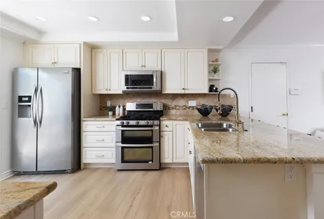 a kitchen with granite countertop a sink stove and refrigerator