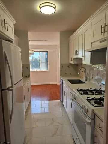 a kitchen with stainless steel appliances granite countertop a stove a refrigerator and a sink