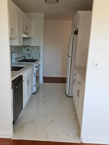 a kitchen with stainless steel appliances a refrigerator and a stove