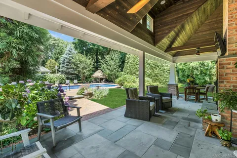 a view of a swimming pool with a table and chairs in patio
