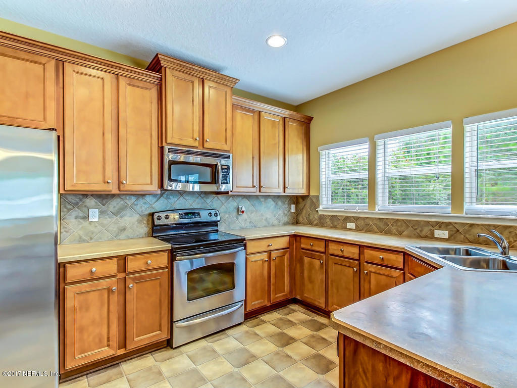 9158 Raptor Drive Jacksonville, FL 32221 - Photo 11 of 45 a kitchen with stainless steel appliances granite countertop a stove a sink and a microwave