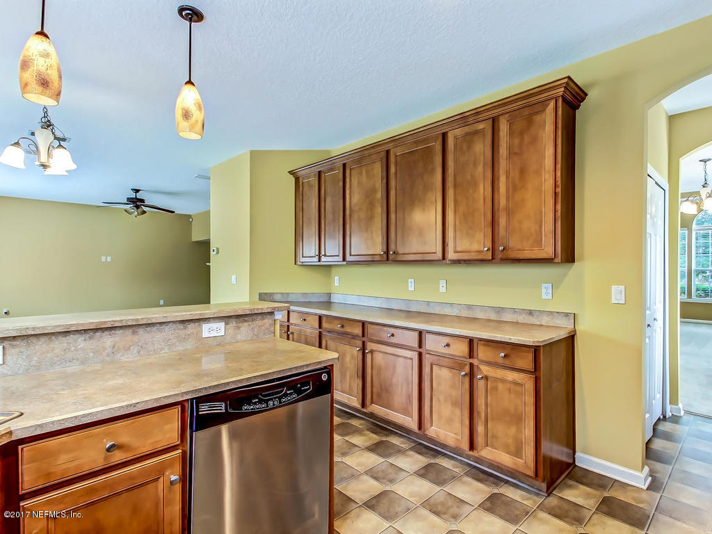 9158 Raptor Drive Jacksonville, FL 32221 - Photo 12 of 45 a kitchen with stainless steel appliances granite countertop a sink a stove and a wooden cabinets