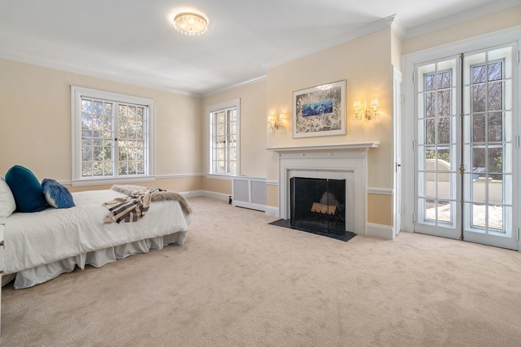 386 Commonwealth Avenue Newton, MA 02467 - Photo 15 of 28 a spacious bedroom with a bed and a fireplace