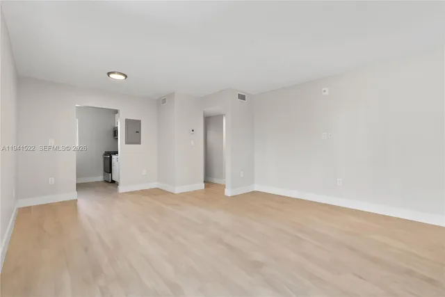 a view of empty room with wooden floor