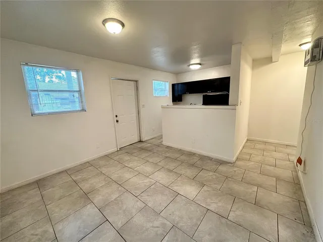 a view of a hallway to room with wooden floor