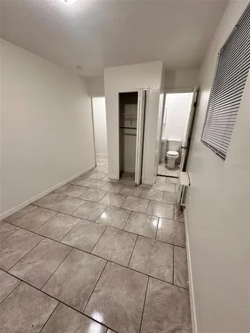 a view of a livingroom with wooden floor and a bathroom