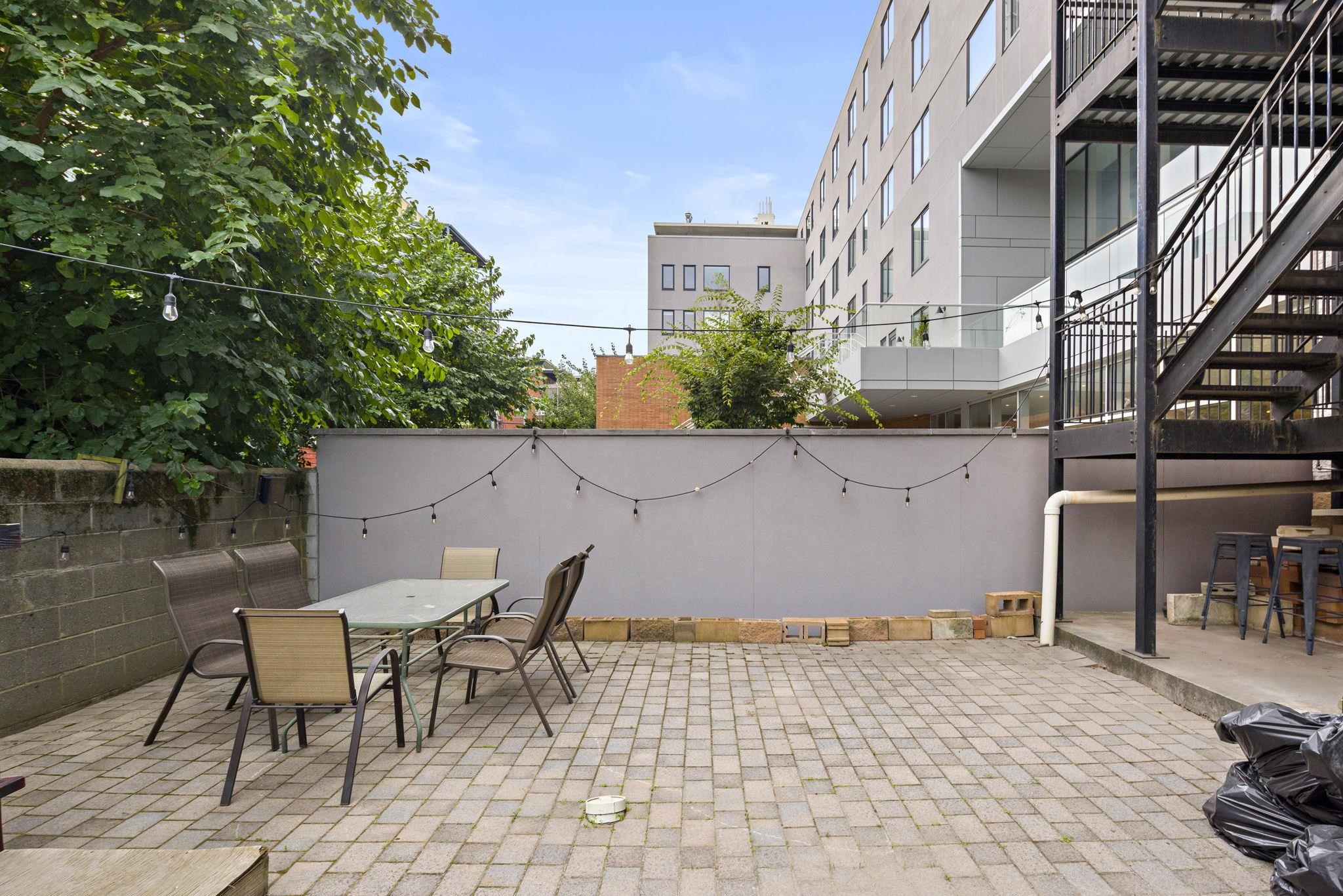 415 Jackson Street, Unit 1R Hoboken, NJ 07030 - Photo 13 of 14 a backyard of a house with table and chairs