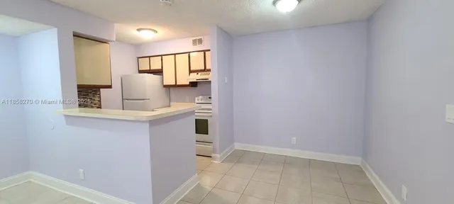 a kitchen with a refrigerator and a stove
