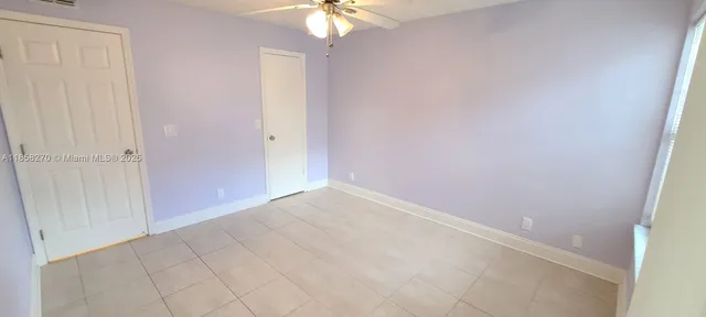 an empty room with windows and fan