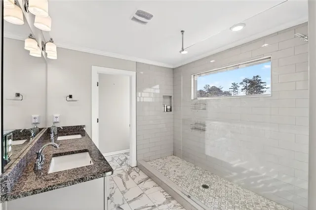 a bathroom with a granite countertop sink a mirror and shower