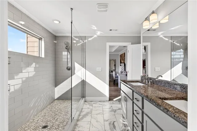 a bathroom with a granite countertop sink mirror and shower