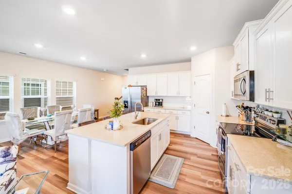 a kitchen with stainless steel appliances kitchen island granite countertop a sink and cabinets