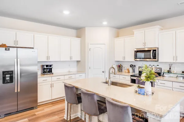 a kitchen with kitchen island a sink stove and refrigerator