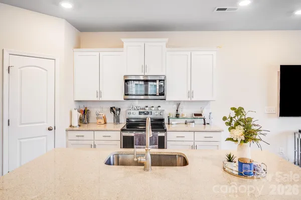 a kitchen with a sink a stove and cabinets