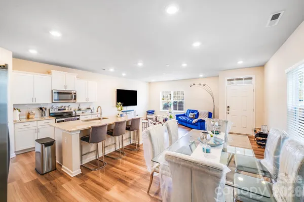 a living room with stainless steel appliances furniture and a view of kitchen
