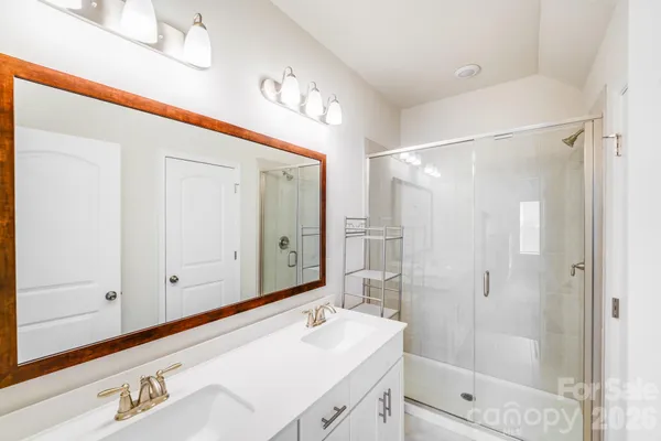 a bathroom with a shower sink and mirror