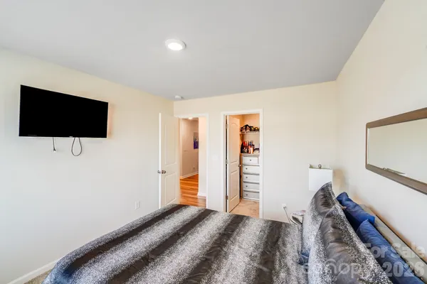 a view of a bedroom with a flat tv screen and a bed