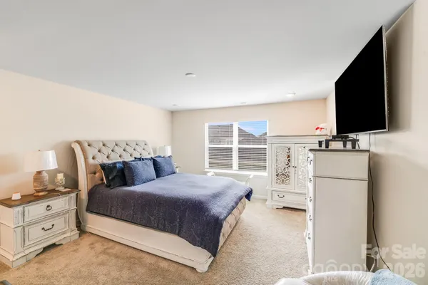 a bedroom with a bed flat screen tv and a window