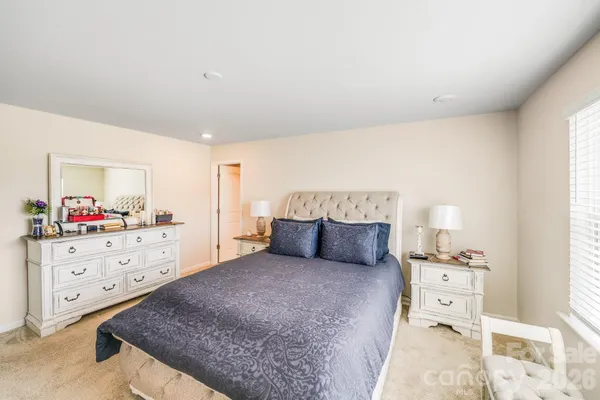 a large bedroom with a bed and a large mirror