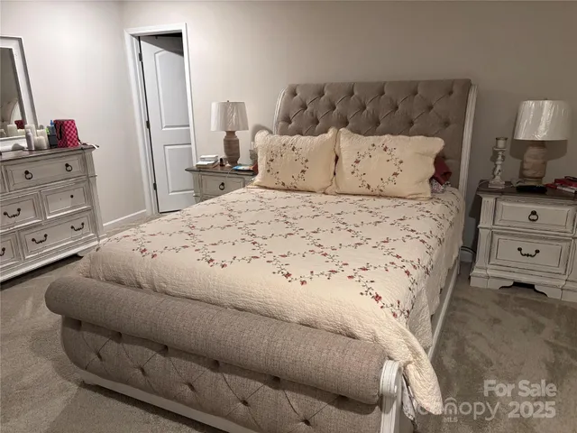a large white bed in a bedroom and dresser