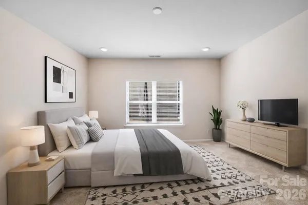 a bedroom with a large bed and a flat screen tv