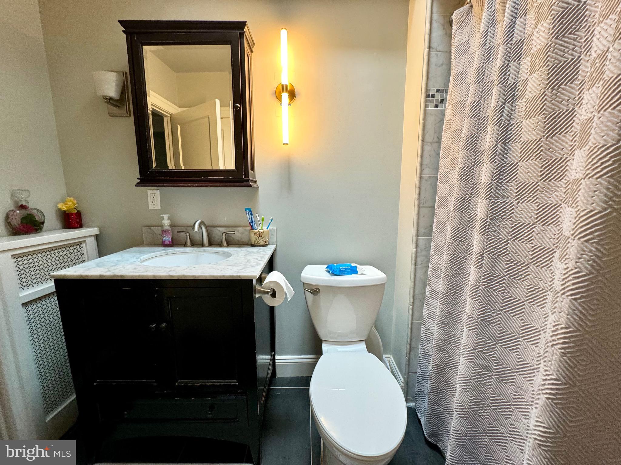 3335 Brighton Street Philadelphia, PA 19149 - Photo 19 of 24 a bathroom with a toilet sink and mirror
