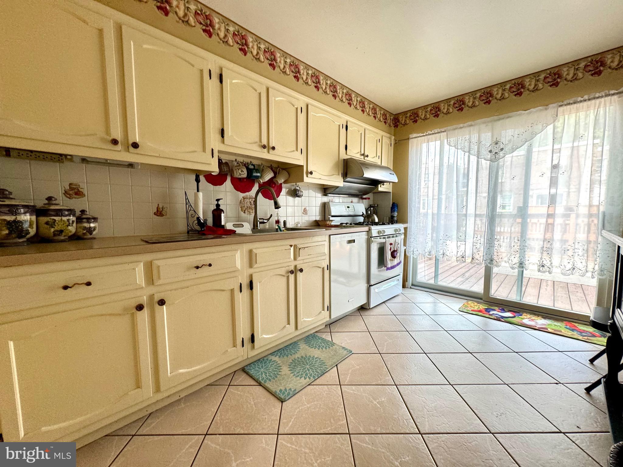 3335 Brighton Street Philadelphia, PA 19149 - Photo 6 of 24 a kitchen with stainless steel appliances granite countertop a sink a stove and white cabinets