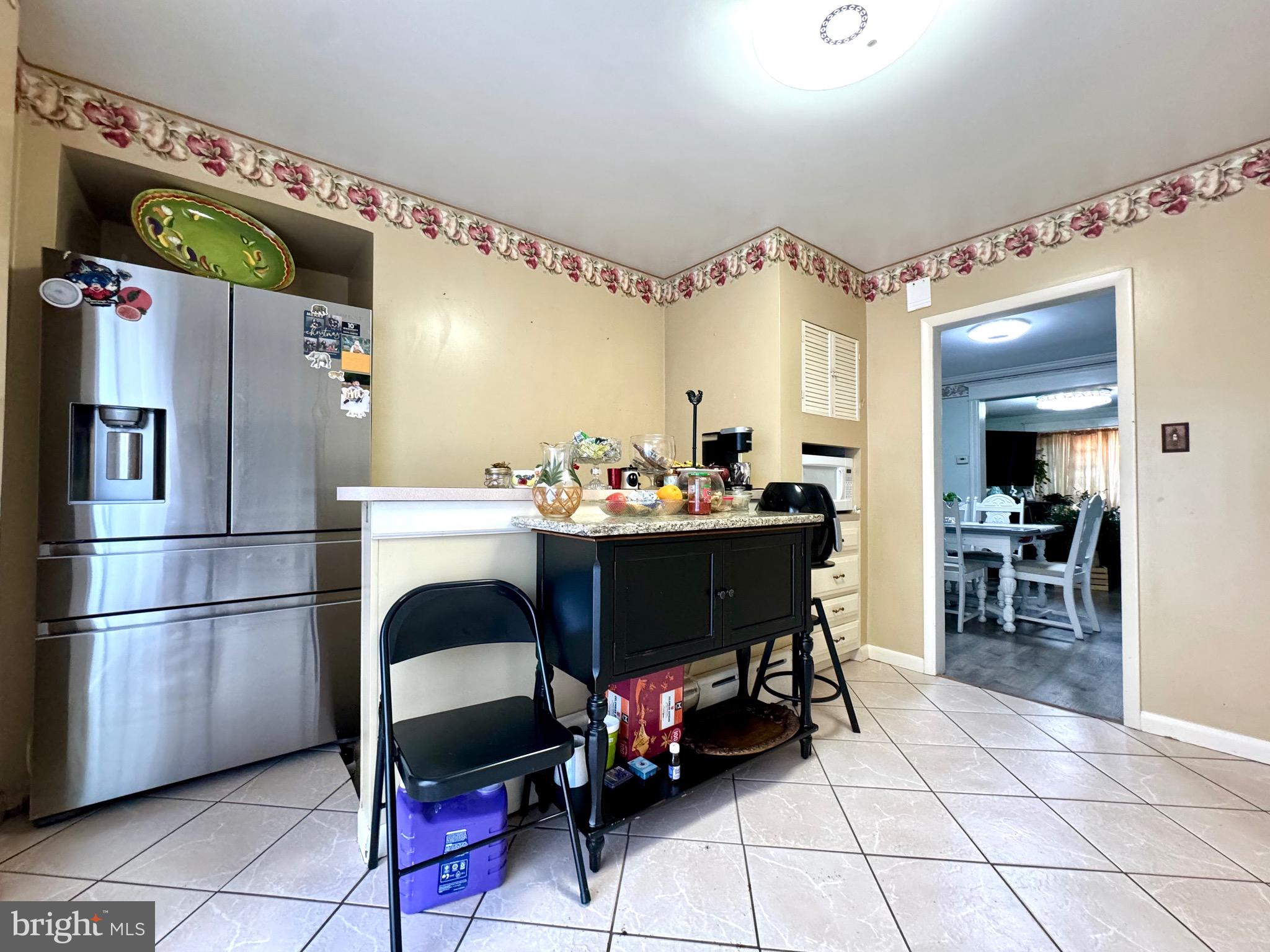 3335 Brighton Street Philadelphia, PA 19149 - Photo 7 of 24 a kitchen with a dining table chairs and refrigerator