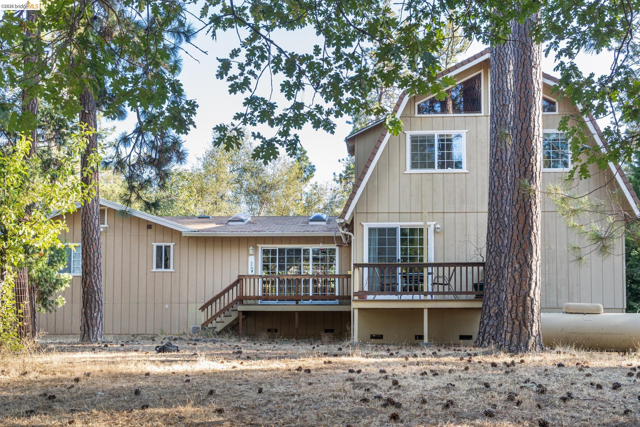 Multi-level exterior with board-and-batten siding, a prominent deck with wooden railings, and multiple windows