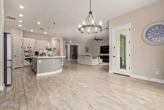 a view of a kitchen with cabinets stainless steel appliances and a chandelier