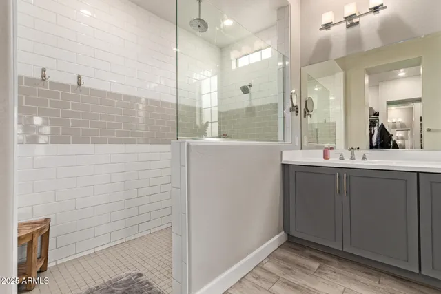 a bathroom with a double vanity sink a mirror and shower