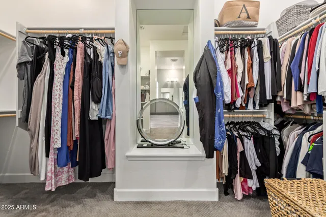 a view of walk in closet with clothes and shoes