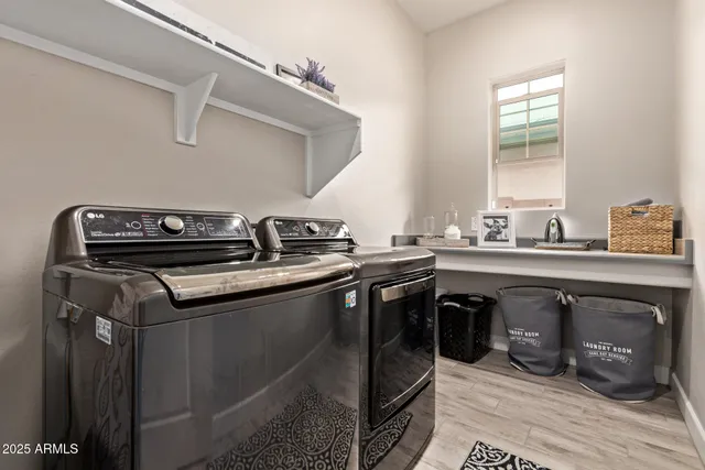 a utility room with stainless steel appliances granite countertop a sink and stove