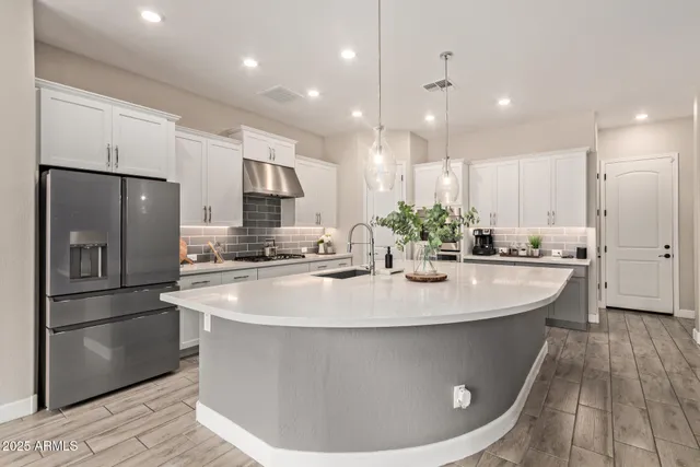 a view of a kitchen with kitchen island a stove a refrigerator and a sink