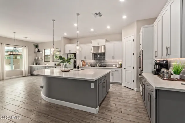 a kitchen with stainless steel appliances granite countertop a large stove a sink dishwasher and a refrigerator with wooden floor