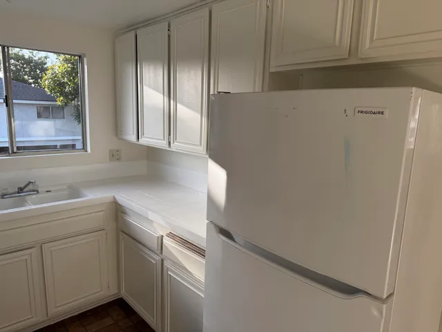 a kitchen with white cabinets and white appliances