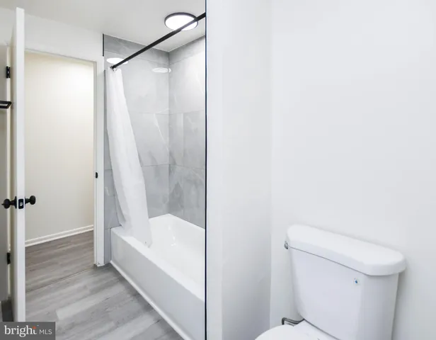a bathroom with a toilet sink and mirror next to a window