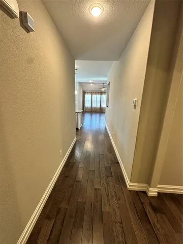 a view of a hallway with wooden floor