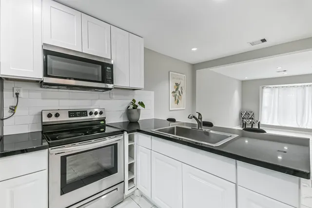 a kitchen with a sink and steel appliances