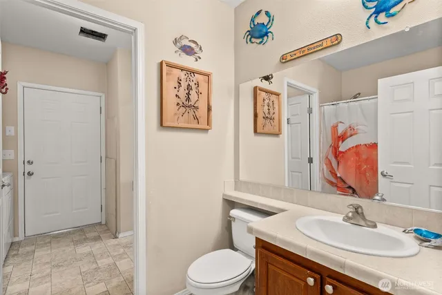 a bathroom with a sink vanity mirror and toilet