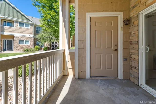 a view of a porch with a door and wooden floor