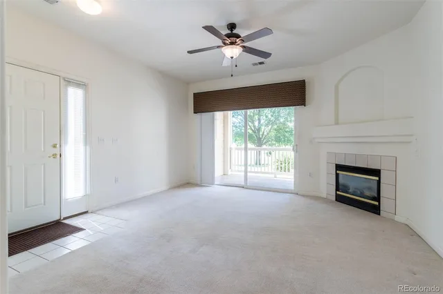 a view of empty room with fireplace and fan